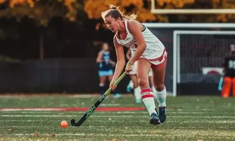 High school field hockey player dribbles