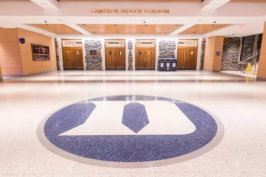 Polished floor in the Rubenstein Pavilion featuring a large Duke “D” logo in blue and white, directly in