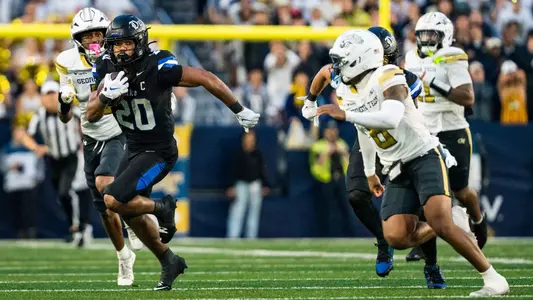 Duke running back Nate Sheppard, wearing a black helmet, black jersey and black pants, holds the ball in his arm and runs away from defenders at Georgia Tech on October 10, 2026.
