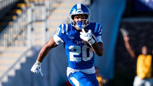Duke running back Nate Sheppard, wearing a blue helmet, blue jersey and blue pants, holds the ball in one arm and runs down the field against William & Mary on September, 26, 2026.