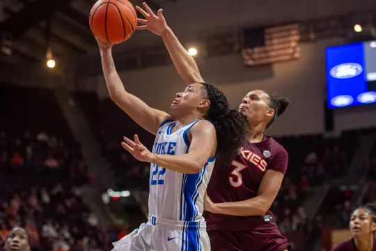 Duke guard Taina Mair goes up for a layup in a white uniform while a Virginia Tech defender contests the shot.