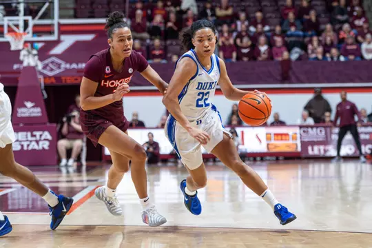 Duke guard Taina Mair dribbles past a Virginia Tech defender in a white uniform during an ACC game.