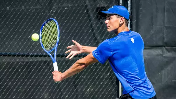 Duke's Dylan Long, wearing a blue hat and blue shirt, watches a ball bounce off his racket during Duke's second round ACC Championship match against Miami at the Cary Tennis Park on April 16, 2026.