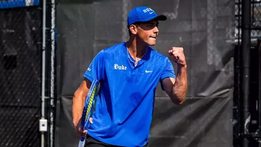 Duke's Dylan Long, wearing a blue hat and blue shirt, fist pumps in celebration during Duke's second round ACC Championship match against Miami at the Cary Tennis Park on April 16, 2026.