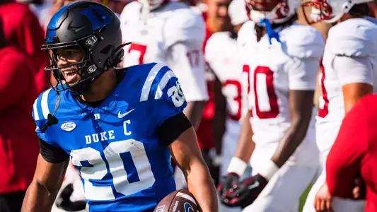 Duke running back Nate Sheppard, wearing a black helmet, blue jersey and black pants, holds the ball and smiles after a gain against Stanford as the Blue Devils picked up a 35-7 win on September 19, 2026.