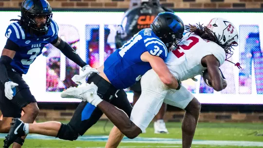 Duke linebacker Elliott Schaper, wearing a black helmet, blue jersey and black pants, makes a tackle during Duke's 35-7 victory against Stanford on September 19, 2026.