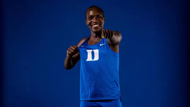 Meshack Kuyo of Duke cross country points at camera wearing Duke uniform