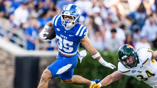 Duke safety Andrew Pellicciotta, wearing a blue helmet, blue shirt and blue pants, holds the ball and runs while returning a punt in Duke's 62-7 victory against William & Mary.