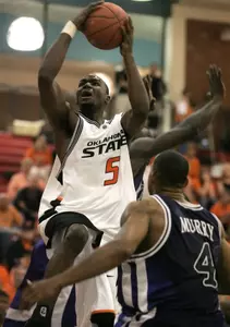 Nile Murry looks on as Oklahoma States's Marcus Dove drives to the basket. (AP Photo/Jae C. Hong)
