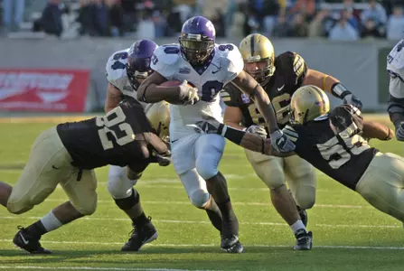 Lonta Hobbs runs through Army players Elliott Antoine (92), Chase McCoy (86) and Barrett Scruggs (55) during the second quarter. (AP Photo/Tim Roske)