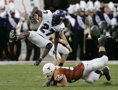 David Roach (27) is upended by Texas guard Charlie Tanner (52) after an interception during the second quarter. (AP Photo/Eric Gay)