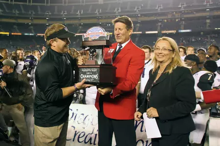 TCU coach Gary Patterson receiving the 2011 Poinsettia Bowl championship trophy.
