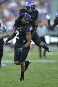 TCU safety Elisha Olabode (top) celebrating a big play by Jason Verrett.
