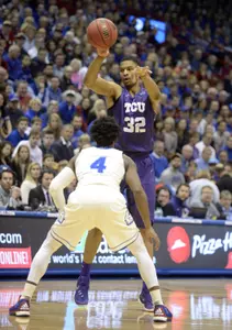 Karviar Shepherd passes against Kansas Jayhawks guard Devonte' Graham.