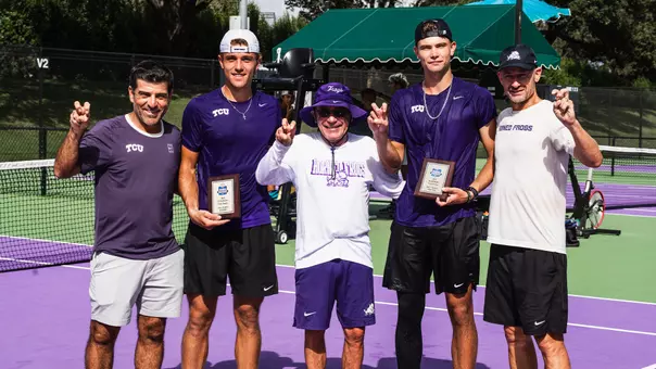 Albert Pedrico and Cooper Woestendick celebrate their ITA Texas Regional doubles championship with the coaching staff