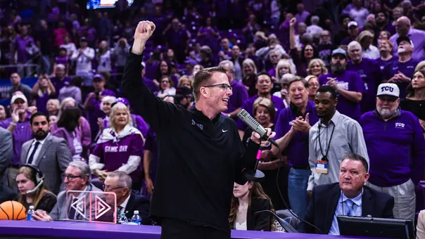 Mark Campbell holds a microphone as he addresses the crowd following an NCAA Tournament win