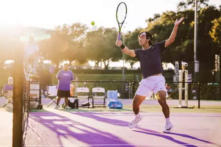 Duncan Chan about to hit a one handed backhand volley while the sun is setting