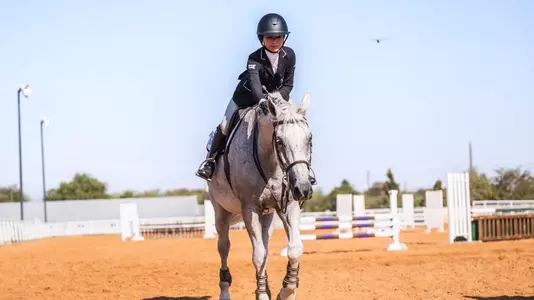Lily Muzzy petting a horse