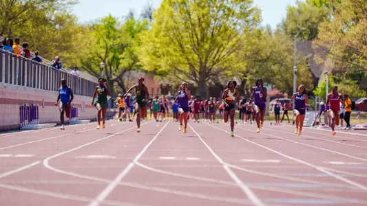 Athletes in the women's 100m dash running down the track