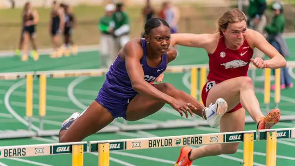 TCU's Amari Kiluvia jumping over a hurdle as she races down the track