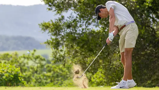 Sam Udovich makes contact with the ball hitting an iron off the tee box.