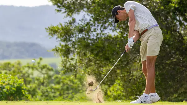 Sam Udovich makes contact with the ball hitting an iron off the tee box.