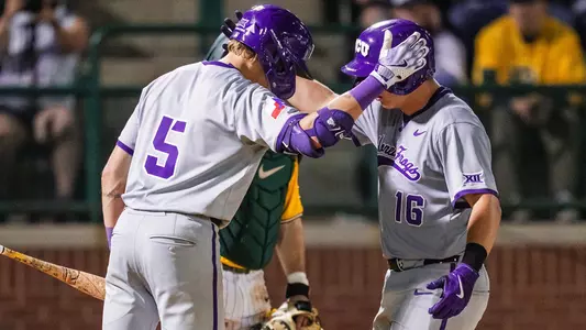 Lucas Franco and Nolan Traeger tap helmets at home plate after Traeger's home run.