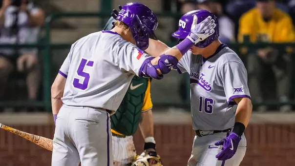 Lucas Franco and Nolan Traeger tap helmets at home plate after Traeger's home run.