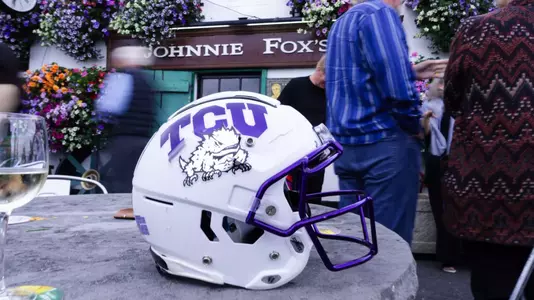 White TCU football helmet on top of a table in front of Johnnie Fox's.
