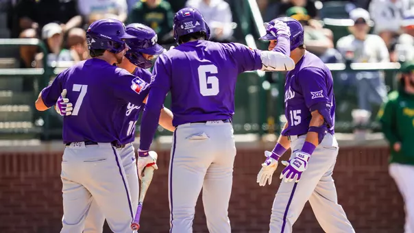 Chase Brunson is greeted at home plate with helmet taps after a three-run home run at Baylor.
