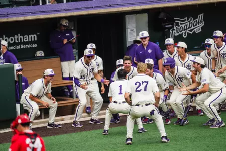 Jack Bell celebrates with his teammates in front of the dugout after a home run.