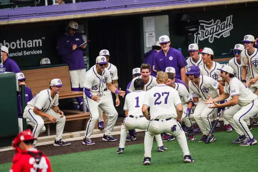 Jack Bell celebrates with his teammates in front of the dugout after a home run.