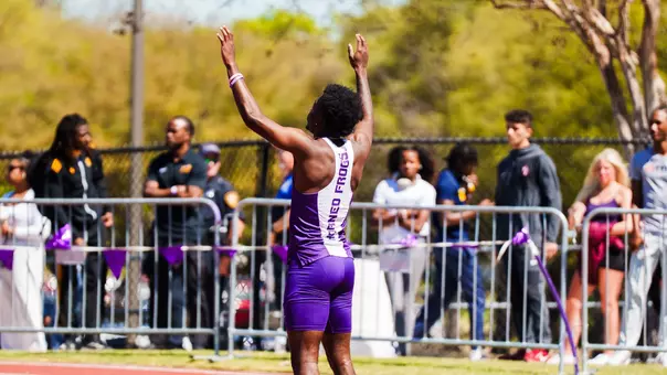 Jayden Douglas stands with his arms in the air before a race
