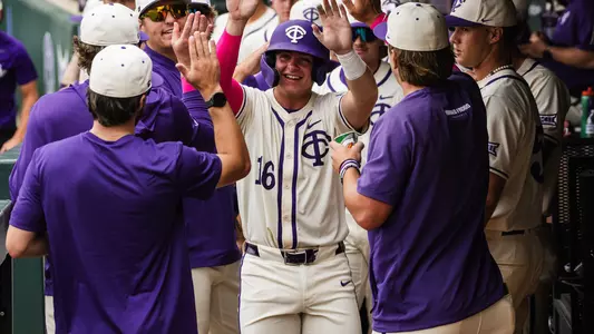 Nolan Traeger receives congratulations from his teammates in the dugout.