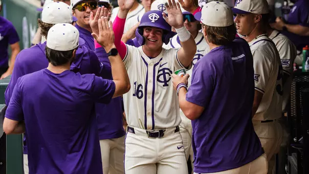 Nolan Traeger receives congratulations from his teammates in the dugout.