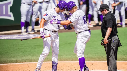 Chase Brunson and Sawyer Strosnider tap helmets at home plate.
