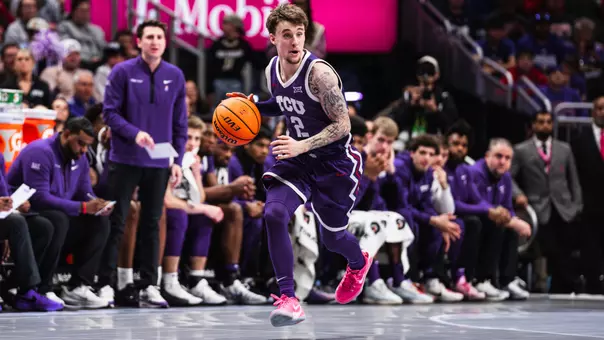 brock harding dribbles the ball up the floor wearing a purple uniform and pink shoes