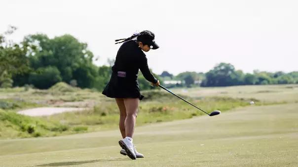 Kirstin Angosta connects with a golf ball on a tee shot.