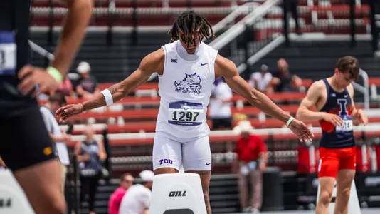 TCU's Ronnie Kendrick standing behind the starting block with his arms outstretched