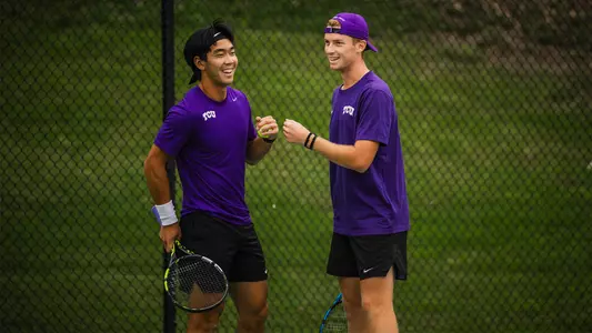 Duncan Chan and Cosme Rolland De Ravel fist bump after winning a point in a doubles match.
