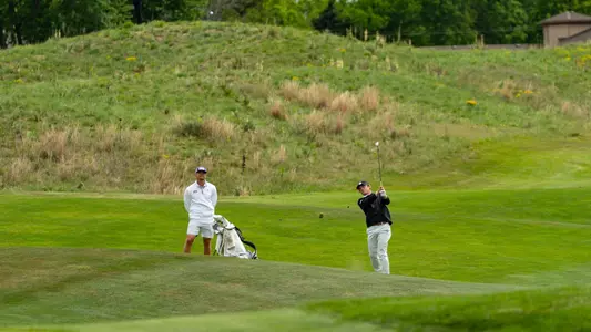 Bill Allcorn watches Charlie Wylie hit an approach shot.