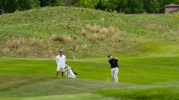 Bill Allcorn watches Charlie Wylie hit an approach shot.