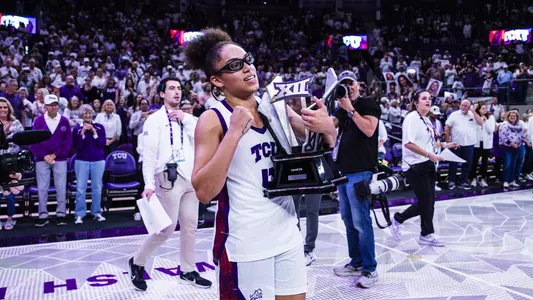 Olivia Miles hoists the Big 12 Championship trophy in front of more than 6,000 fans at Schollmaier Arena.