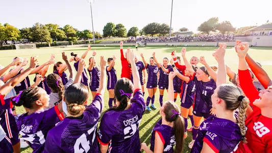 TCU women's soccer team throwing up Frog sign