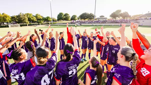 TCU women's soccer team throwing up Frog sign