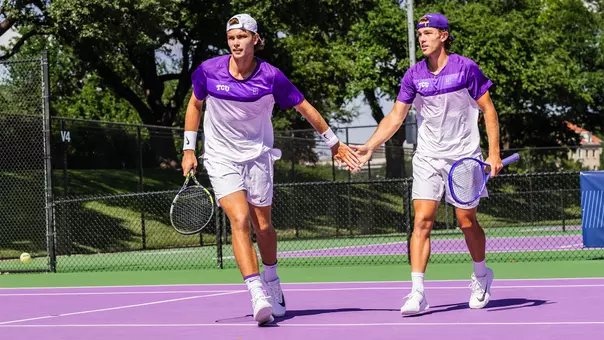 Albert Pedrico and Cooper Woestendick celebrate a point in a doubles match.