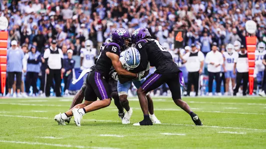 Group of TCU defenders tackling a North Carolina player