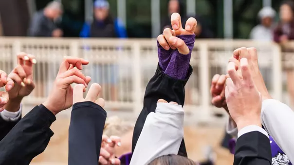 TCU beach volleyball players with the Frog Sign
