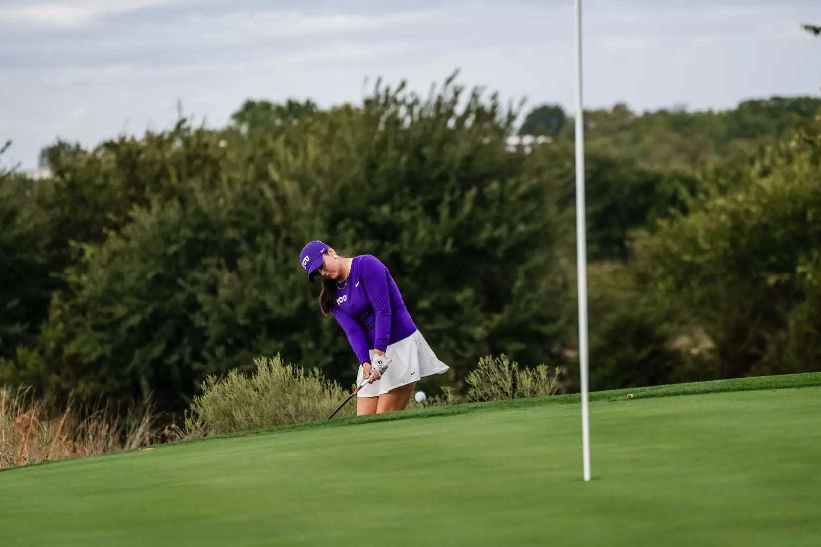 Gracie McGovern chips from the fringe and watches her ball land on the green.