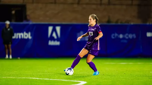 Grace Coppinger with possesion of ball looking for passing target